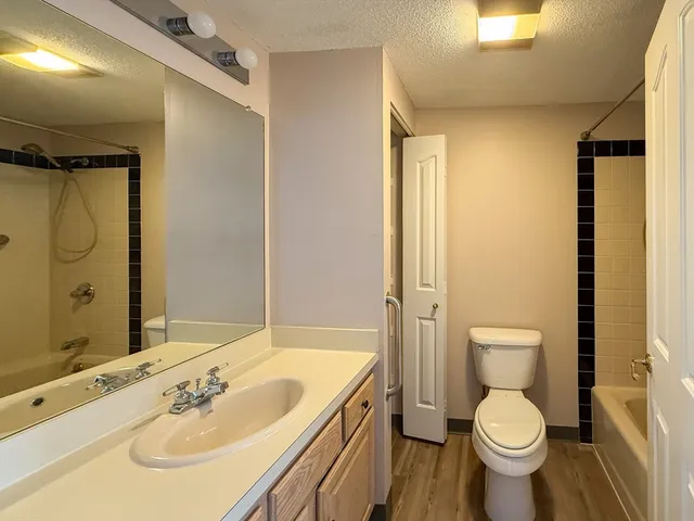 a bathroom with a granite countertop toilet sink and mirror