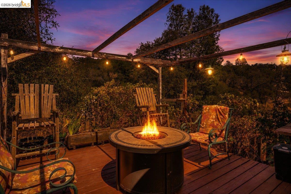 14450 Jacksonville Road Jamestown, CA 95327 - Photo 44 of 85 Deck with pergola and string lighting, featuring a built-in fire pit