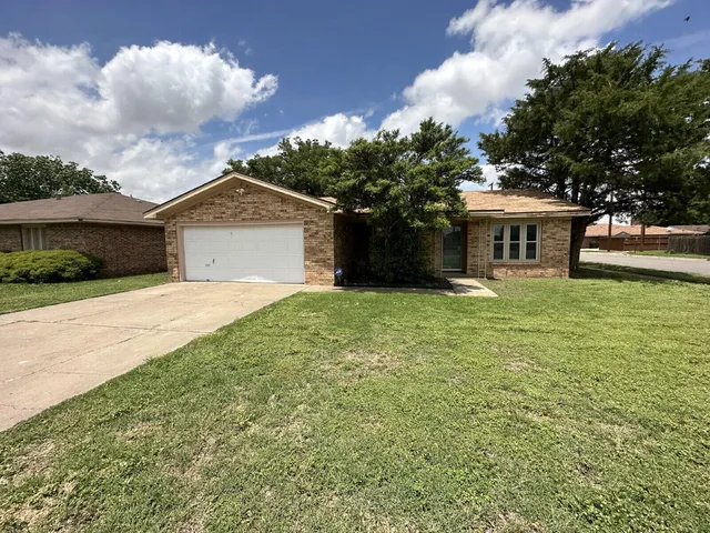 a front view of a house with a garden and trees
