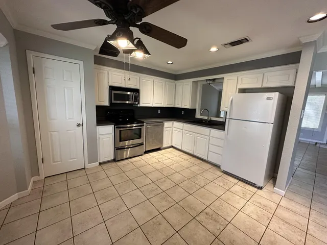 a kitchen with granite countertop a refrigerator a sink and dishwasher