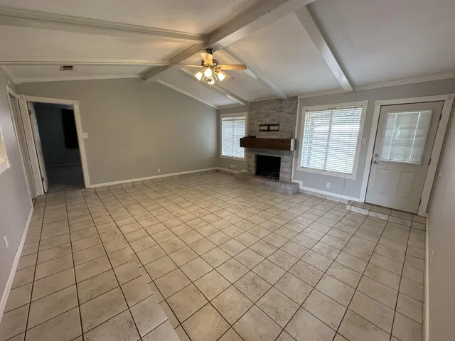 an empty room with fireplace and windows