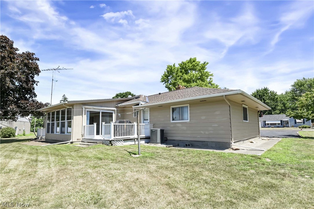 3690 Long Road Avon, OH 44011 - Photo 35 of 41 Back of property with central air condition unit, a sunroom, and a yard