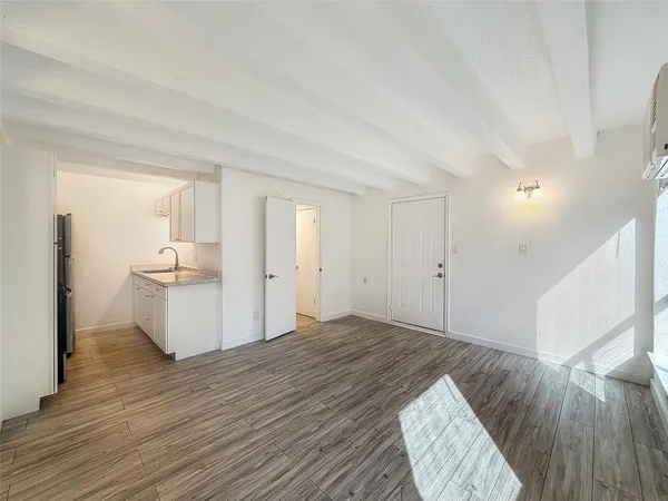 a view of a bedroom with wooden floor and window
