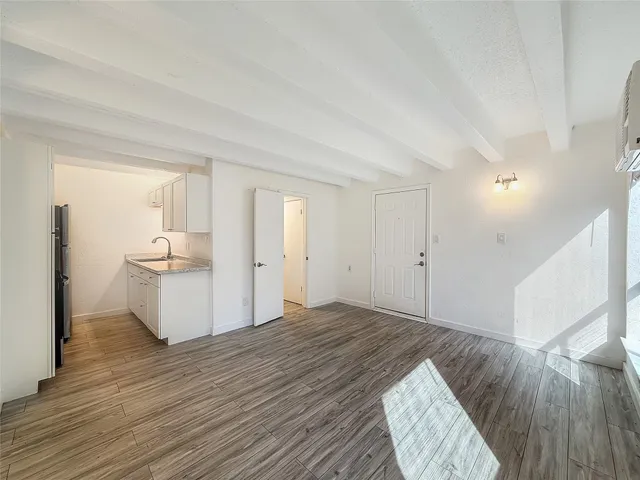 a view of a bedroom with wooden floor and window