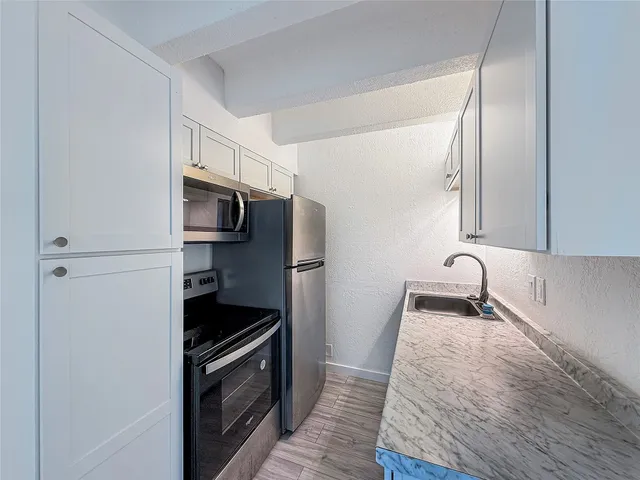 a kitchen with granite countertop a stove and a microwave