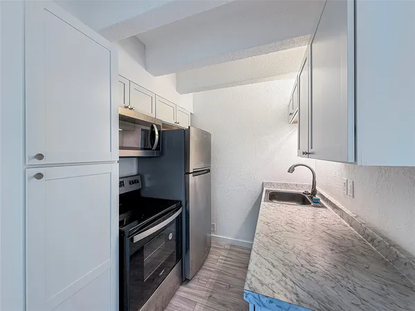 a kitchen with granite countertop a stove and a microwave