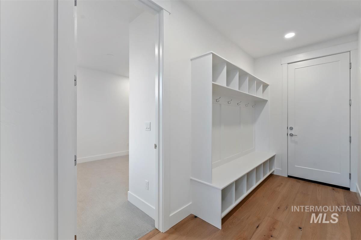 3213 West Moore Street Boise, ID 83702 - Photo 5 of 32 Entryway featuring built-in white cabinetry with cubbies and coat hooks, wood-finish flooring, recessed lighting, and a solid white door with brushed nickel hardware