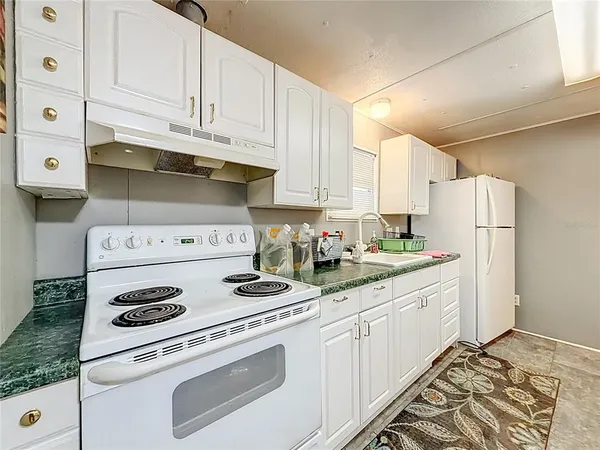 a kitchen with white cabinets and white appliances