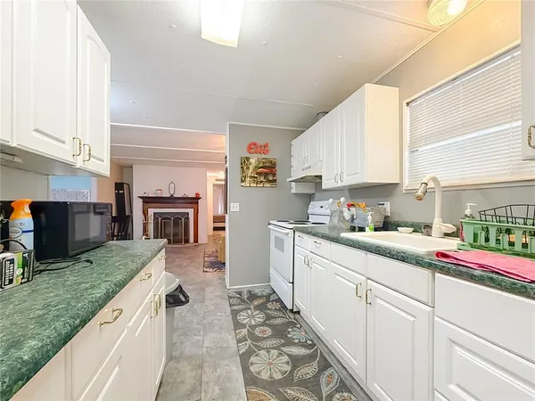 a kitchen with granite countertop a sink stove top oven and cabinets