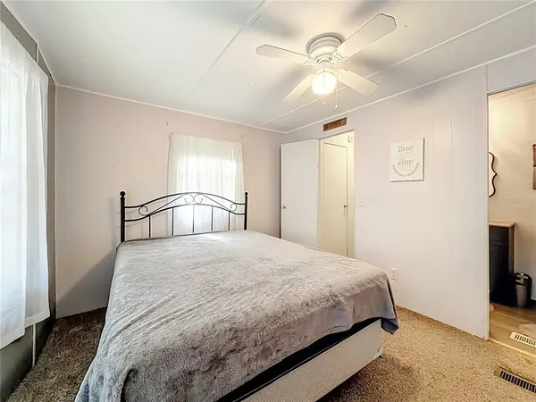 a bedroom with a bed and a flat tv screen on dresser