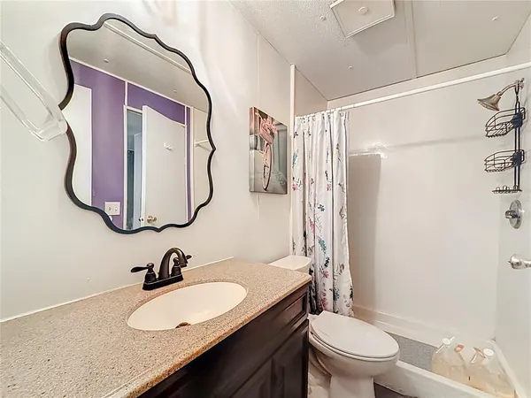 a bathroom with a granite countertop sink toilet and shower