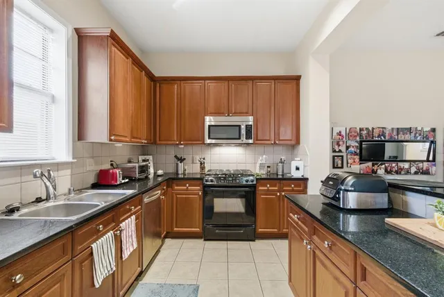 a kitchen with stainless steel appliances granite countertop a sink stove and cabinets