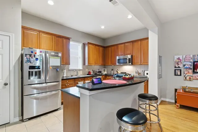 a kitchen with stainless steel appliances granite countertop a sink stove and refrigerator