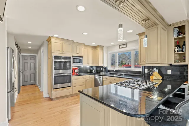 a kitchen with stainless steel appliances granite countertop a sink and a stove