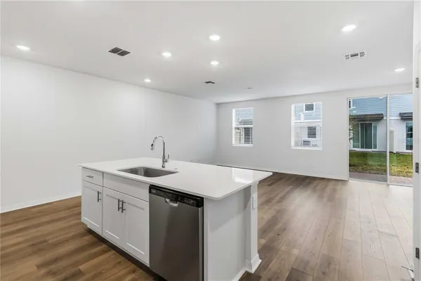 a kitchen that has a sink and a wooden floor