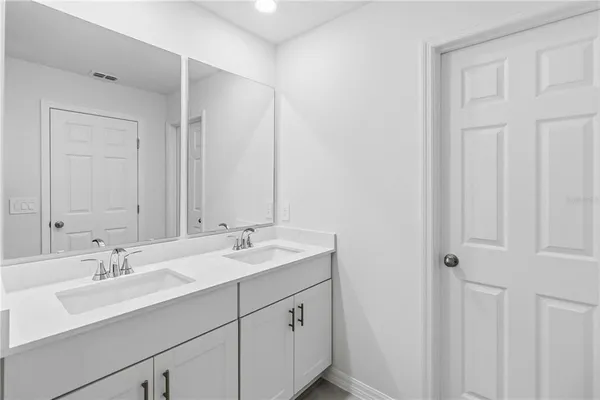 a bathroom with a double vanity sink and a mirror