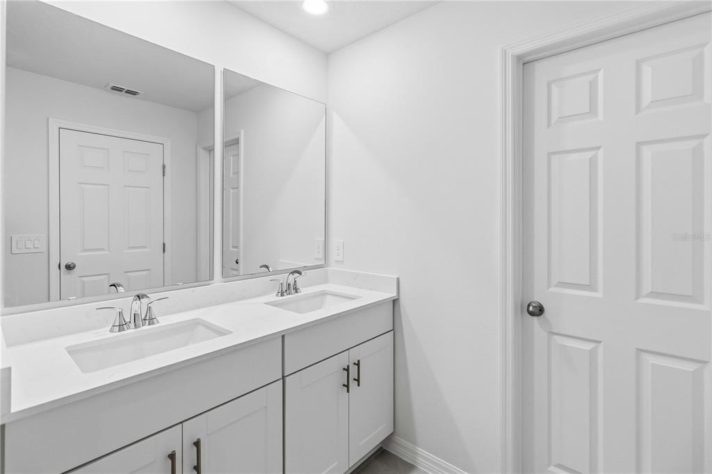 4571 Range Land Way St. Cloud, FL 34772 - Photo 21 of 43 a bathroom with a double vanity sink and a mirror