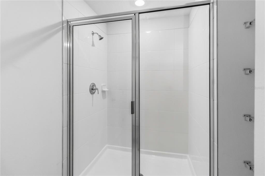 4571 Range Land Way St. Cloud, FL 34772 - Photo 22 of 43 a bathroom with a glass shower door