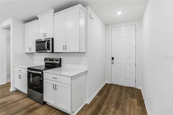 a kitchen with cabinets appliances and a wooden floor