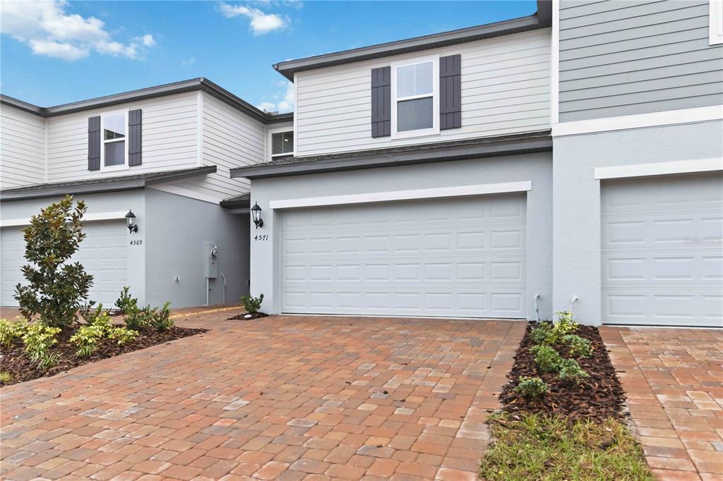 4571 Range Land Way St. Cloud, FL 34772 - Photo 32 of 43 a front view of a house with a yard and garage