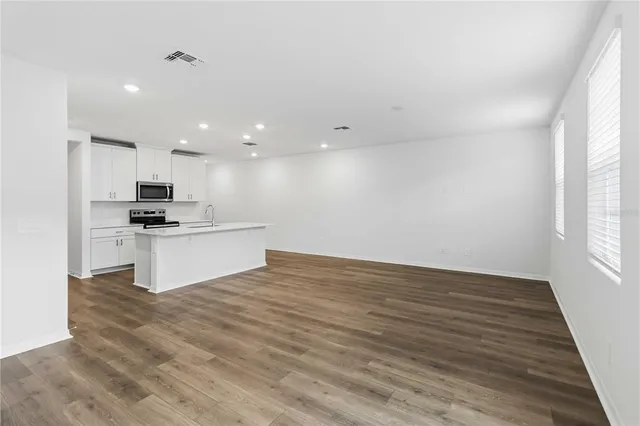a view of kitchen with granite countertop a sink and cabinets