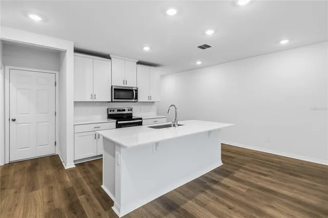 a kitchen with a sink a microwave a stove and refrigerator