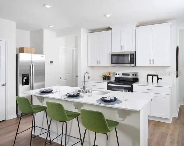 4571 Range Land Way St. Cloud, FL 34772 - Photo 9 of 43 a kitchen with stainless steel appliances kitchen island granite countertop a dining table and chairs