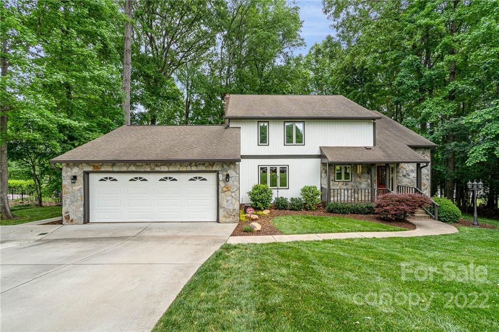 4525 Rounding Run Road Charlotte, NC 28277 - Photo 3 of 44 a front view of a house with a garden and trees