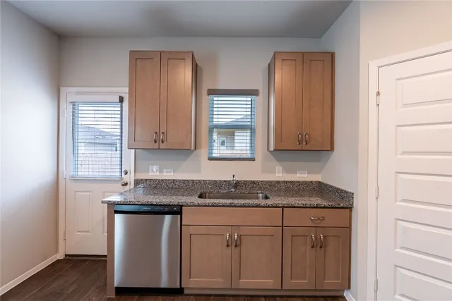 a kitchen with granite countertop white cabinets and sink