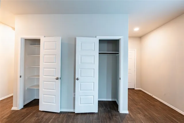 an empty room with wooden floor & window