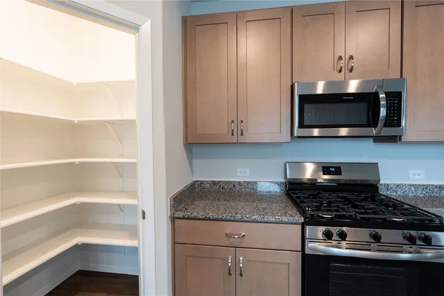 a kitchen with granite countertop cabinets stainless steel appliances and a sink