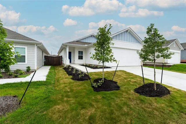 a view of a house with backyard and sitting area