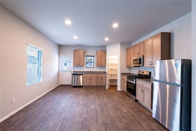 a kitchen with a refrigerator wooden floor and a sink