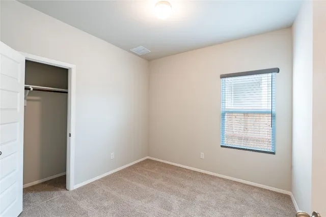 a view of an empty room with closet area