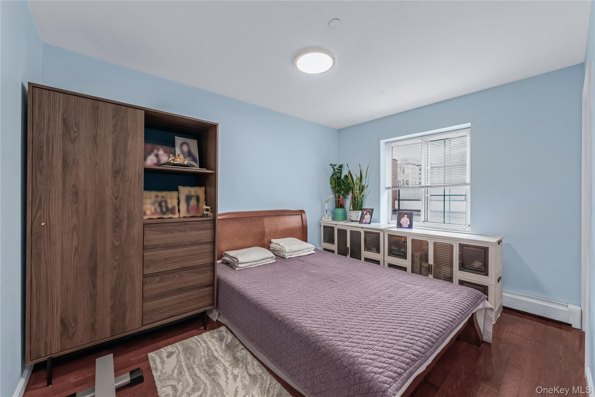 35-06 Leavitt Street, Unit 3K Queens, NY 11354 - Photo 7 of 17 Bedroom featuring a baseboard radiator and dark wood finished floors