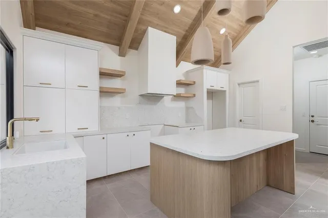 a kitchen with a sink dishwasher and white cabinets