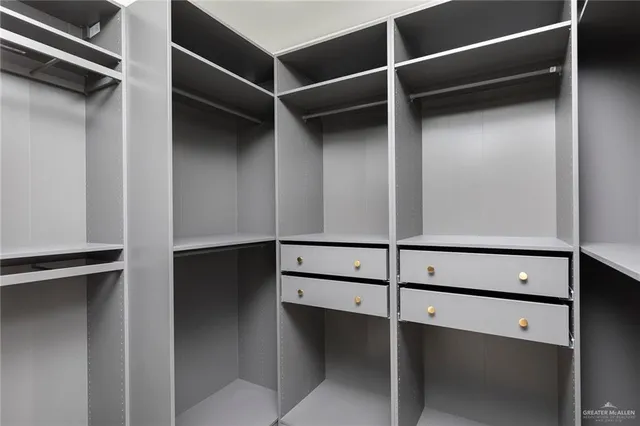 a view of walk in closet with empty racks