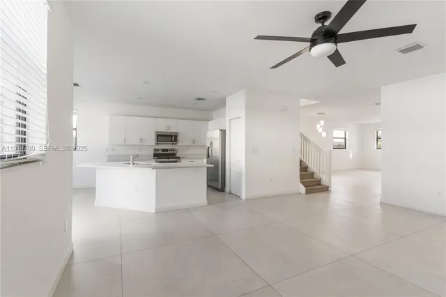 a view of kitchen with stainless steel appliances refrigerator oven and cabinets