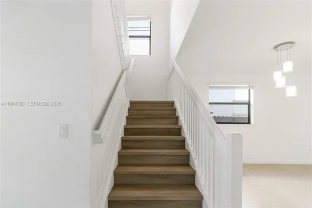 an empty room with wooden floor and ceiling fan
