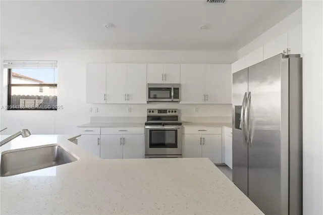 a kitchen with refrigerator cabinets and a sink