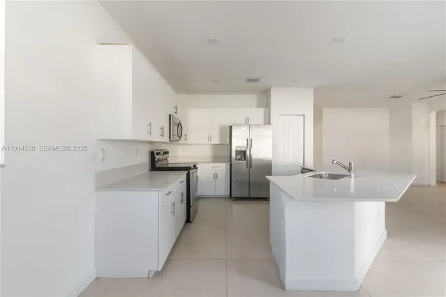 a view of a room with a stylish ceiling fan and wooden floor