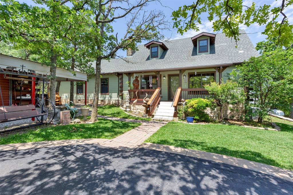 161 Cheyenne Drive Nocona, TX 76255 - Photo 1 of 1 Cape cod-style house featuring roof with shingles, a porch, and a front lawn