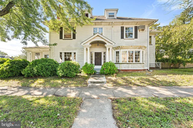 a view of a house next to a yard with plants and trees
