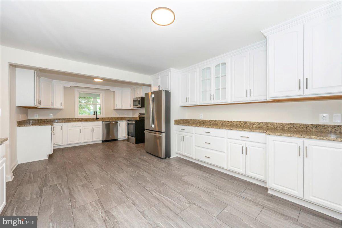 1802 Ridge Road Westminster, MD 21157 - Photo 12 of 47 a kitchen with granite countertop white cabinets and stainless steel appliances