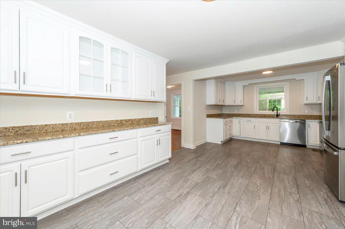 1802 Ridge Road Westminster, MD 21157 - Photo 13 of 47 a kitchen with granite countertop white cabinets and wooden floor