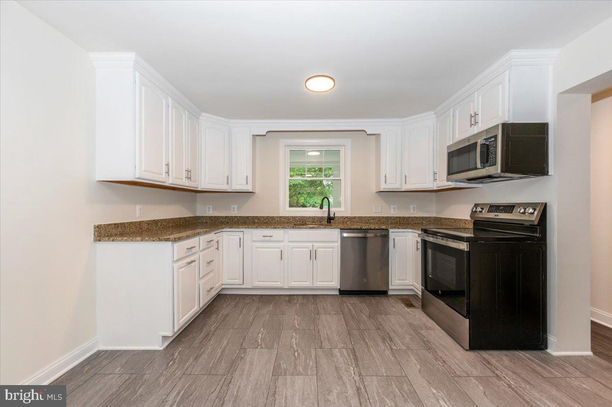 1802 Ridge Road Westminster, MD 21157 - Photo 15 of 47 a kitchen with granite countertop a stove top oven a sink dishwasher and a refrigerator with wooden floor