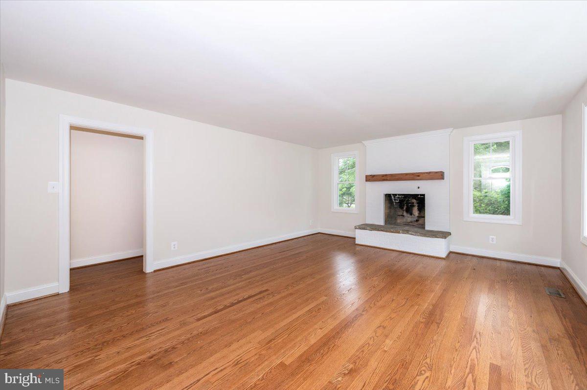1802 Ridge Road Westminster, MD 21157 - Photo 4 of 47 an empty room with wooden floor a fireplace and a window