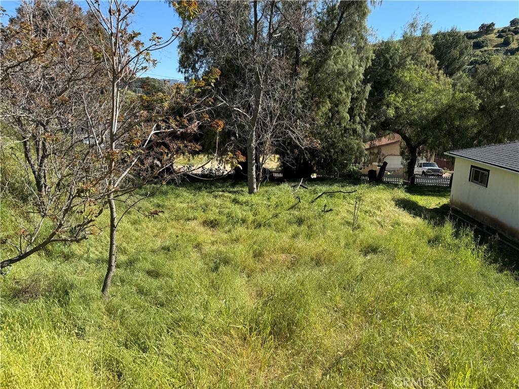 a backyard of a house with table and chairs under an umbrella