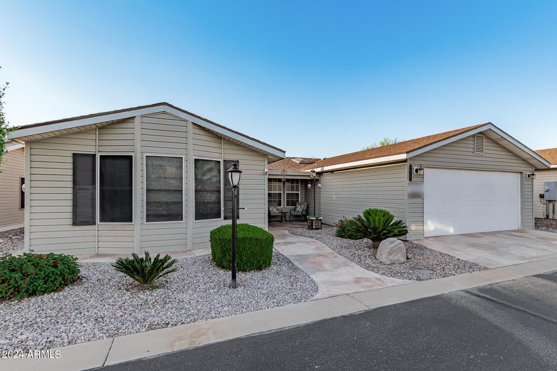 3301 South Goldfield Road, Unit 4037 Apache Junction, AZ 85119 - Photo 2 of 36 a front view of a house with a yard and a garage