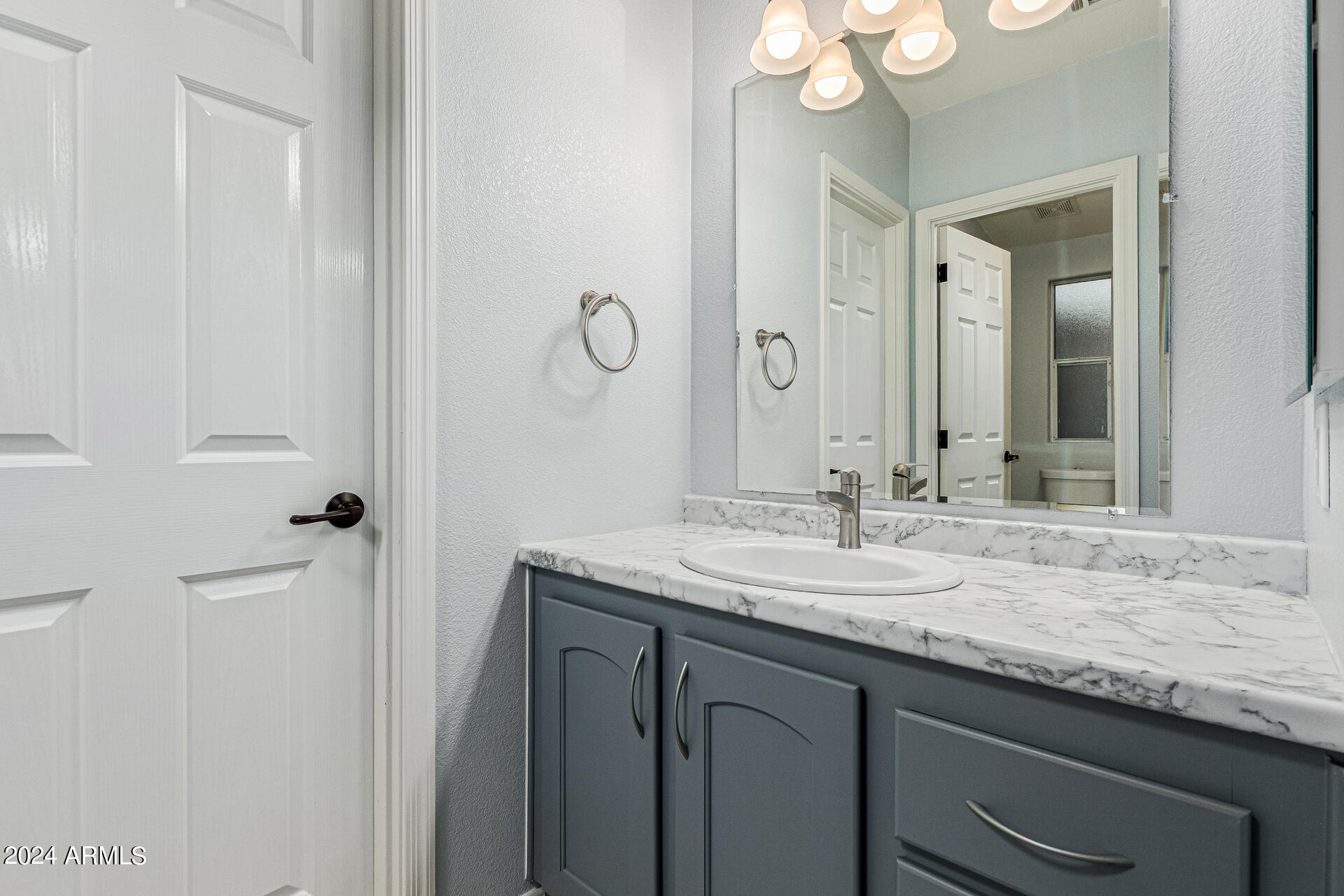3301 South Goldfield Road, Unit 4037 Apache Junction, AZ 85119 - Photo 27 of 36 a bathroom with a granite countertop sink and a mirror